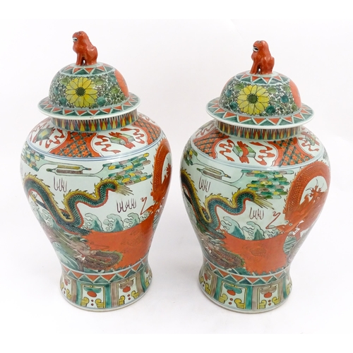 4 - A large pair of Chinese ginger jars decorated with dragons above stylised waves, bordered by flowers... 