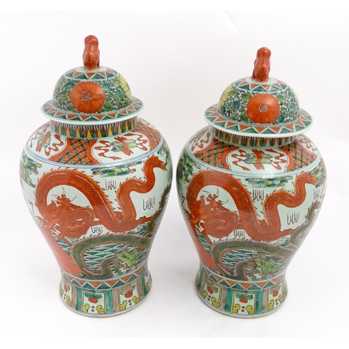 4 - A large pair of Chinese ginger jars decorated with dragons above stylised waves, bordered by flowers... 