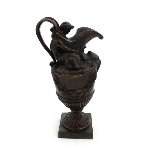 1228 - A 19thC cast bronze ewer cast in the Classical style modelled with Neptune supporting the spout and ... 