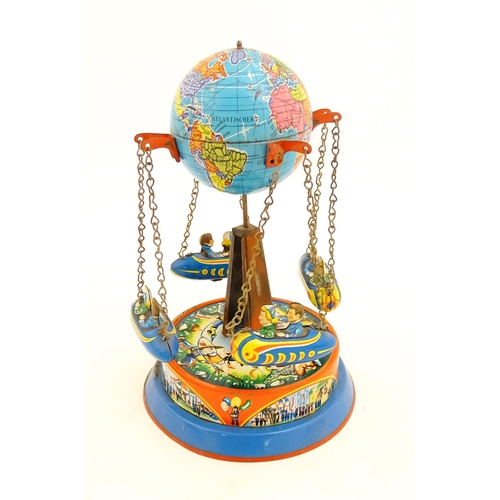 1271 - Toy: A vintage tin plate toy modelled as a fairground ride / carousel with world globe to top suppor... 