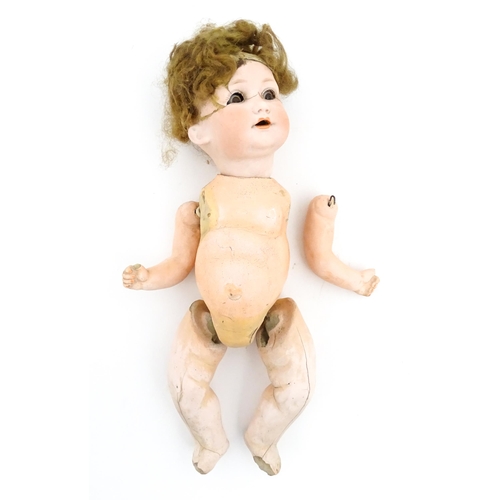 1281 - Toys: A small German doll with a bisque head and composite body. Together with a quantity of doll pa... 