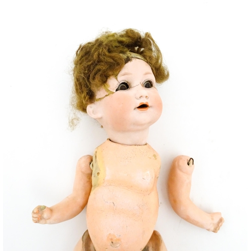 1281 - Toys: A small German doll with a bisque head and composite body. Together with a quantity of doll pa... 