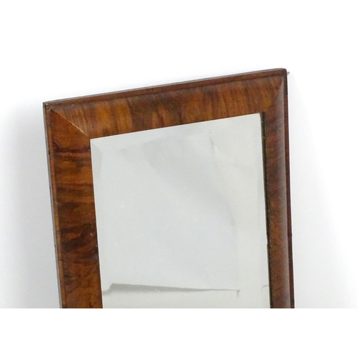 1434 - An 18thC mirror with a later bevelled glass and walnut veneers. 15