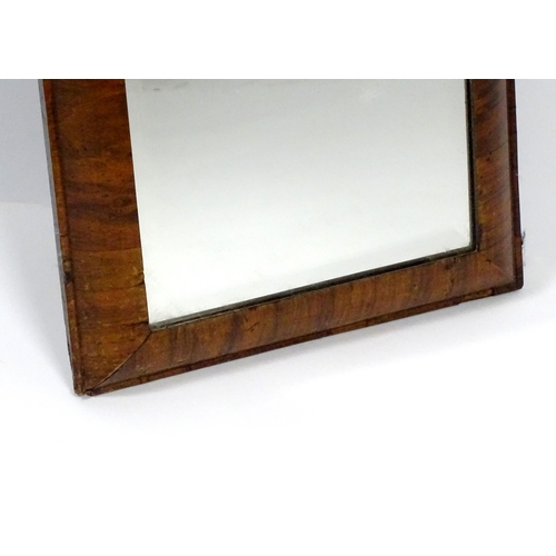 1434 - An 18thC mirror with a later bevelled glass and walnut veneers. 15