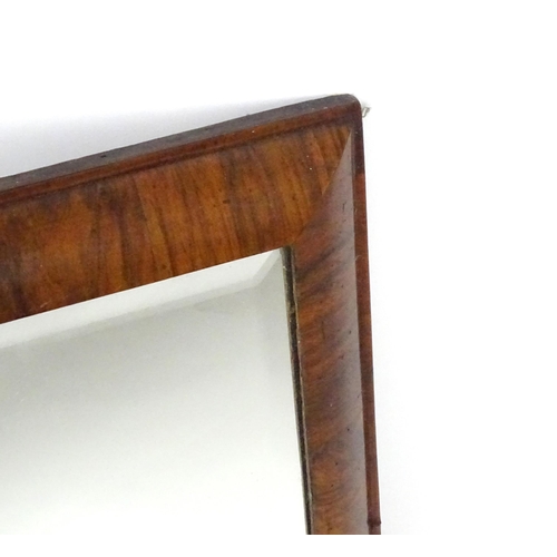 1434 - An 18thC mirror with a later bevelled glass and walnut veneers. 15