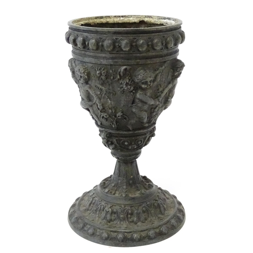 357 - A 20thC cast vase of goblet form decorated in relief with Bacchanalian putti. Approx. 9 3/4