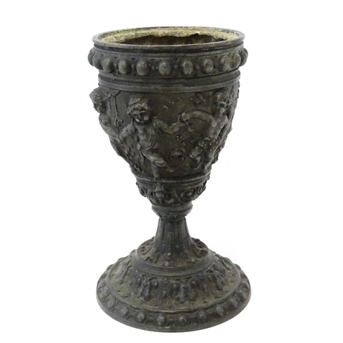 357 - A 20thC cast vase of goblet form decorated in relief with Bacchanalian putti. Approx. 9 3/4