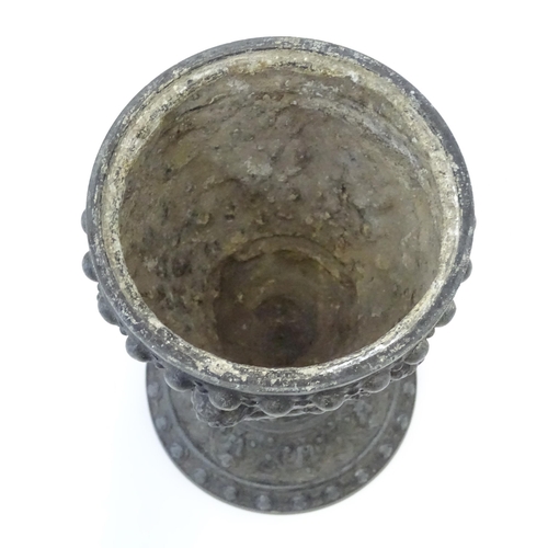 357 - A 20thC cast vase of goblet form decorated in relief with Bacchanalian putti. Approx. 9 3/4