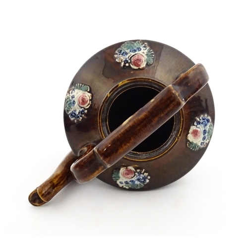 148 - A 19thC Measham bargeware teapot on stand decorated with flowers and foliage. Approx. 9 1/4