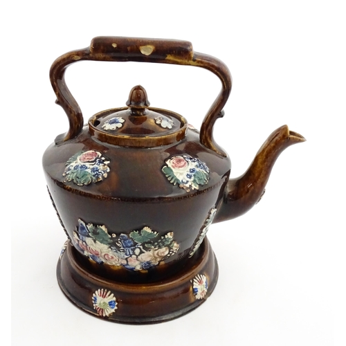 148 - A 19thC Measham bargeware teapot on stand decorated with flowers and foliage. Approx. 9 1/4
