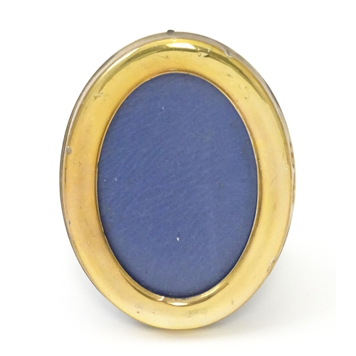 463 - An easel back photograph frame of oval form with Continental silver gilt surround, marked .925 and w... 