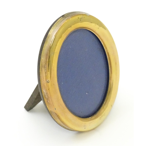 463 - An easel back photograph frame of oval form with Continental silver gilt surround, marked .925 and w... 