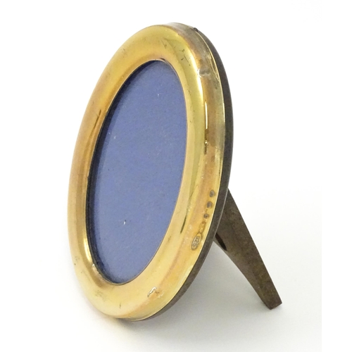 463 - An easel back photograph frame of oval form with Continental silver gilt surround, marked .925 and w... 