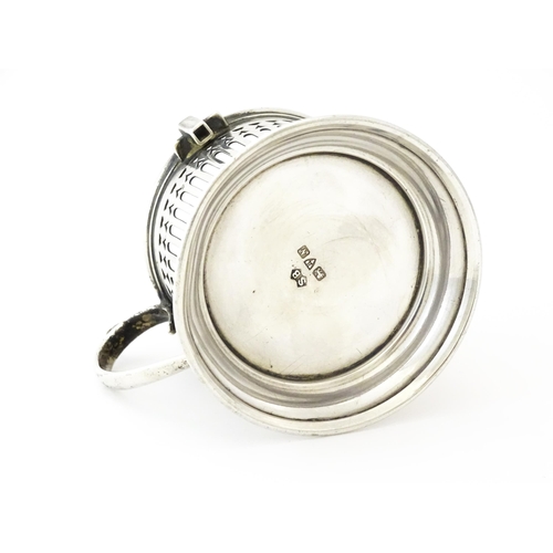 394 - A silver cup holder / sleeve with pierced detail, hallmarked Chester 1913, maker Simpson & Benzie. A... 