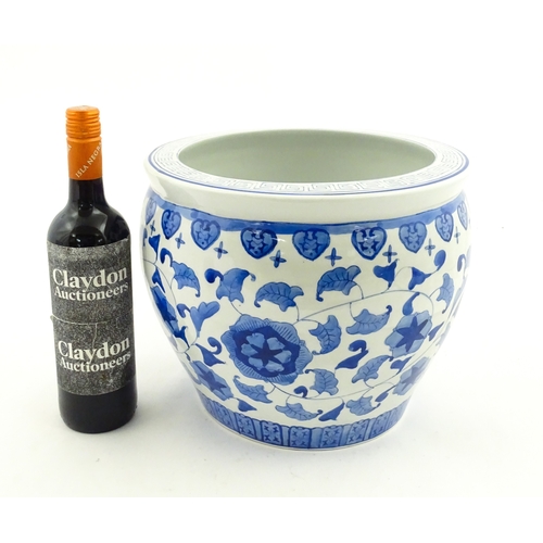 153 - An Oriental blue and white planter with floral and foliate decoration. Approx. 10