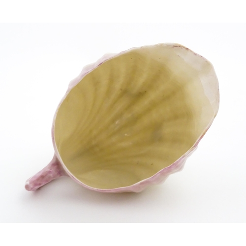 80 - A Belleek milk jug in the Neptune pattern with shell detail. Marked under. Approx. 3