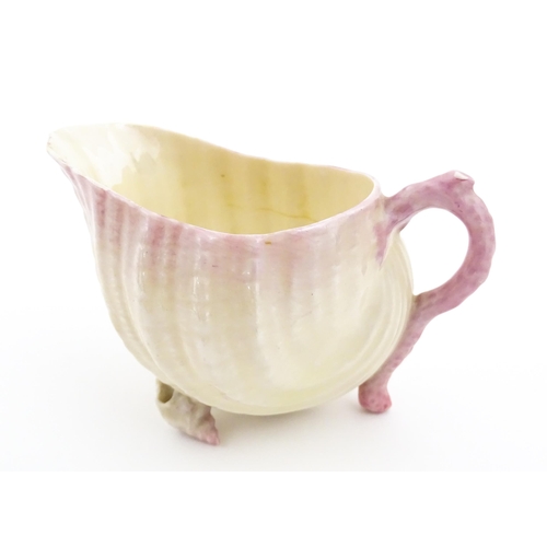 80 - A Belleek milk jug in the Neptune pattern with shell detail. Marked under. Approx. 3