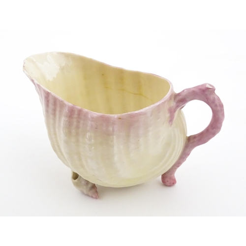 80 - A Belleek milk jug in the Neptune pattern with shell detail. Marked under. Approx. 3