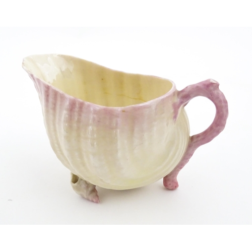 80 - A Belleek milk jug in the Neptune pattern with shell detail. Marked under. Approx. 3