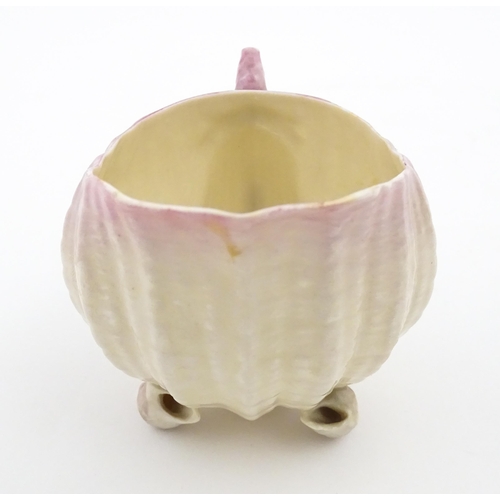 80 - A Belleek milk jug in the Neptune pattern with shell detail. Marked under. Approx. 3