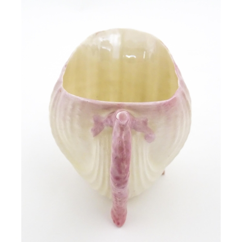 80 - A Belleek milk jug in the Neptune pattern with shell detail. Marked under. Approx. 3