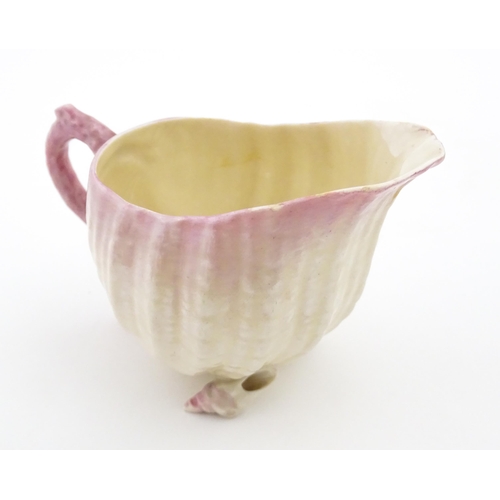 80 - A Belleek milk jug in the Neptune pattern with shell detail. Marked under. Approx. 3