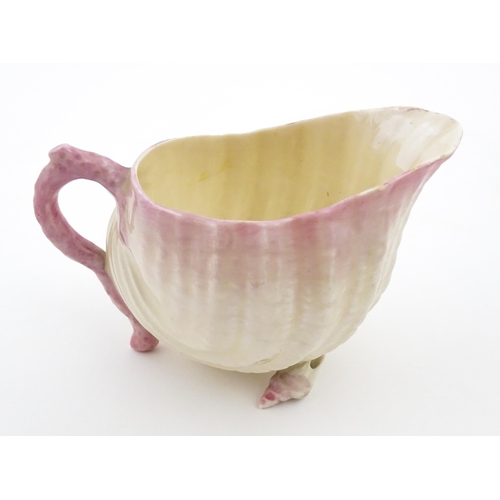 80 - A Belleek milk jug in the Neptune pattern with shell detail. Marked under. Approx. 3