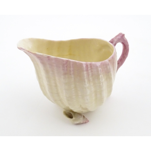 80 - A Belleek milk jug in the Neptune pattern with shell detail. Marked under. Approx. 3