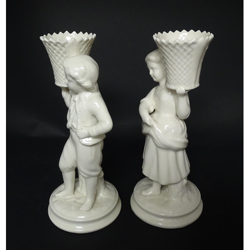 82 - A pair of Belleek figures comprising Girl Basket Carrier and Boy Basket Carrier. Marked under. Appro... 