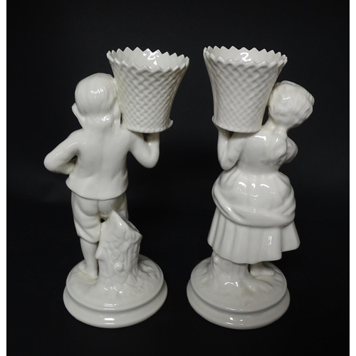 82 - A pair of Belleek figures comprising Girl Basket Carrier and Boy Basket Carrier. Marked under. Appro... 