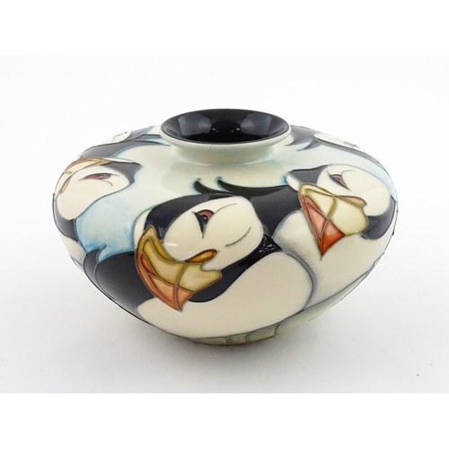 102 - A Moorcroft vase of squat form decorated with puffins. Marked under. With box. Approx. 3 1/2