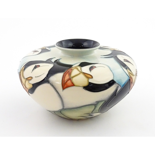 102 - A Moorcroft vase of squat form decorated with puffins. Marked under. With box. Approx. 3 1/2