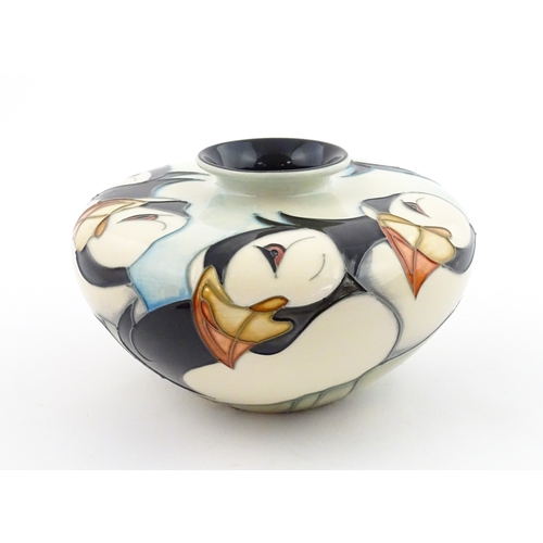 102 - A Moorcroft vase of squat form decorated with puffins. Marked under. With box. Approx. 3 1/2