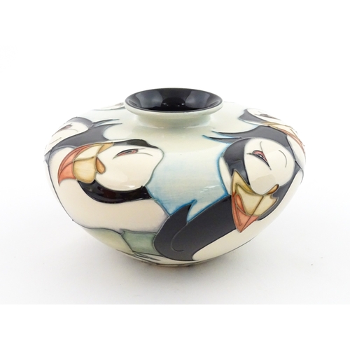 102 - A Moorcroft vase of squat form decorated with puffins. Marked under. With box. Approx. 3 1/2