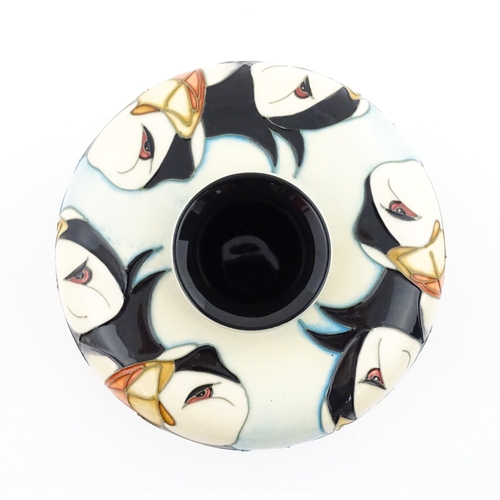 102 - A Moorcroft vase of squat form decorated with puffins. Marked under. With box. Approx. 3 1/2