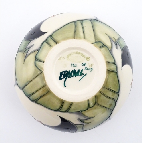 102 - A Moorcroft vase of squat form decorated with puffins. Marked under. With box. Approx. 3 1/2