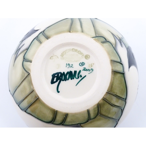 102 - A Moorcroft vase of squat form decorated with puffins. Marked under. With box. Approx. 3 1/2