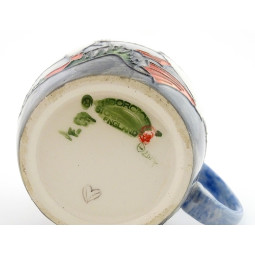 104 - A Moorcroft mug decorated with puffins. Marked under. Approx. 3 1/2
