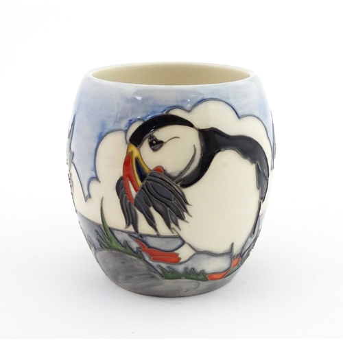 104 - A Moorcroft mug decorated with puffins. Marked under. Approx. 3 1/2