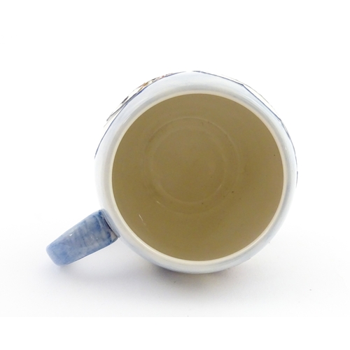 104 - A Moorcroft mug decorated with puffins. Marked under. Approx. 3 1/2