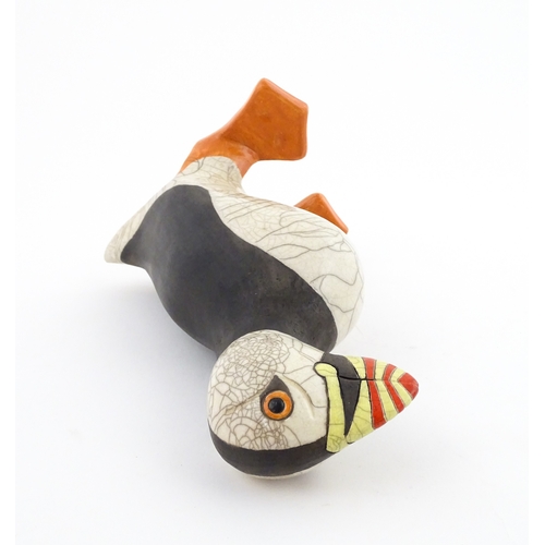 90 - A studio pottery raku fired model of a puffin by Tony White. Marked under. Approx. 9 3/4