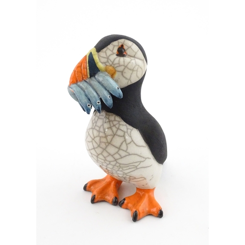 91 - A studio pottery raku fired model of a puffin by Chloe Harford. Marked under. Approx. 6 3/4