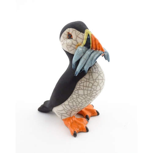 91 - A studio pottery raku fired model of a puffin by Chloe Harford. Marked under. Approx. 6 3/4