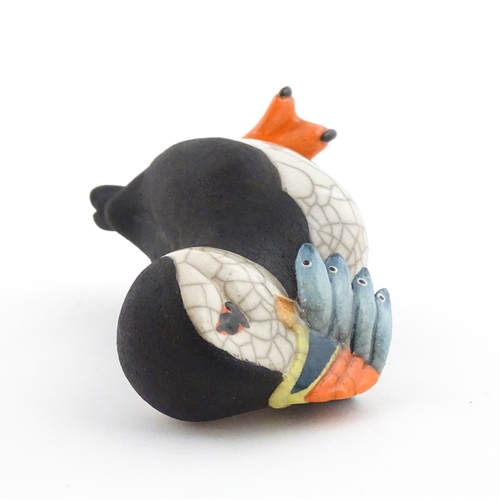 91 - A studio pottery raku fired model of a puffin by Chloe Harford. Marked under. Approx. 6 3/4