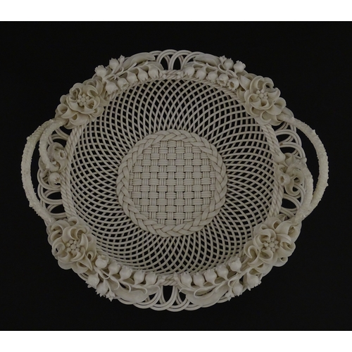 67 - A Belleek three strand Lily Basket having lattice work with ribbon edges, decorated with lily of the... 