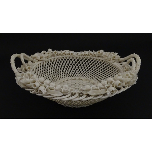 67 - A Belleek three strand Lily Basket having lattice work with ribbon edges, decorated with lily of the... 
