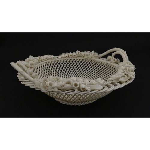 67 - A Belleek three strand Lily Basket having lattice work with ribbon edges, decorated with lily of the... 