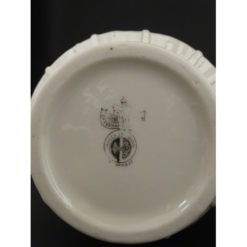 69 - A pair of Belleek vases in the Nile pattern having cala lily and foliate detail, with lustre highlig... 