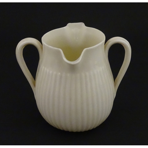 70 - A Belleek Lifford pattern double spout cream jug with twin handles. Marked with Second Period mark u... 