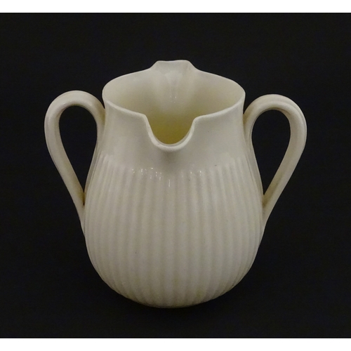 70 - A Belleek Lifford pattern double spout cream jug with twin handles. Marked with Second Period mark u... 